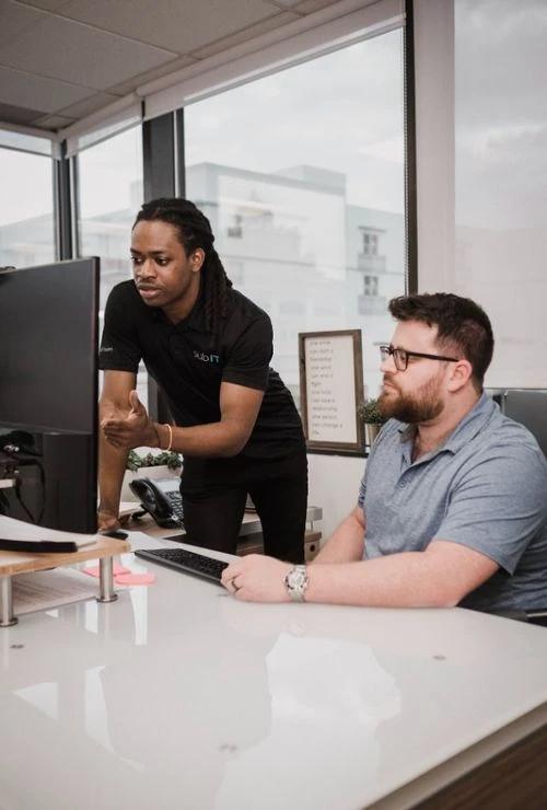 Two colleagues collaborating at a computer desk