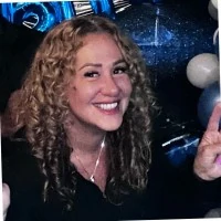 Smiling woman with curly hair at a party