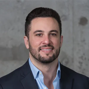 Smiling man in suit against gray background