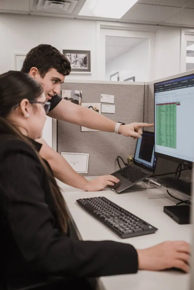 Coworkers analyzing data on computer screen at office